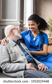 Vertical photo of helpful young female doctor nurse consulting old elderly man . 80s senior man talking about health condition and medicine with woman general practitioner.