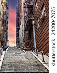 Vertical photo of the Joker stairs at an orange sunrise or sunset in the famous Bronx neighborhood, the famous borough of New York in USA.