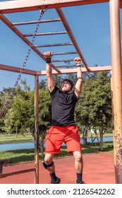 Vertical Photo Of A Man Crossing The Brachiation Ladder Or Monkey Bar Strengthening His Body