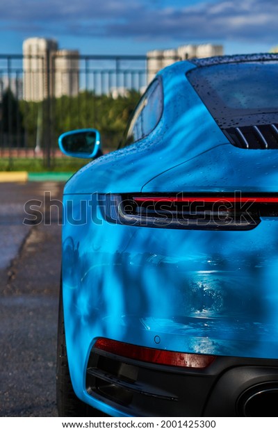 Vertical photo of Porsche 911 Carrera 4S (Miami\
Blue) 992 Sports with space for text rear view of trunk and\
headlights. High quality\
photo