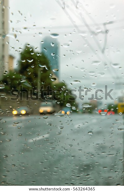Vertical\
photo of the rain outside through a wet\
glass