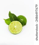 Vertical photo of two limes and one lime that has been cut in half and the leaves behind them on an isolated white background