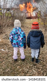 A Vertical Photo Two Toddlers Watching A House Burning Down .