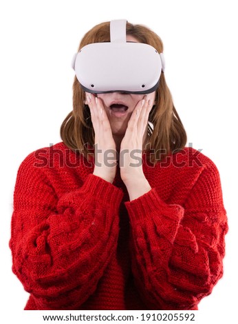 vertical photo vr glasses. girl wearing VR glasses on a light background, surprised by the new experience of gaming technologies