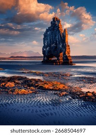 Vertical picture of huge basalt stack - Hvitserkur. Majestic morning scene of eastern shore of Vatnsnes peninsula. Dramatic summer sunrise in northwest Iceland. Beauty of nature concept background.