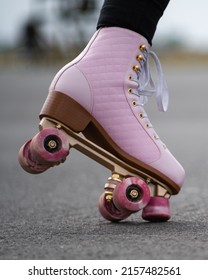 Vertical Picture Of Person Rollerskating, Close Up Of Pink Vintage Quad Roller Skates. Concept: Leisure Activities. Movement, Summer, Sports, Vacations, Free Time, Outdoor Activities. 