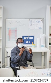 Vertical Portrait Of African American Teacher Wearing Mask And Holding Molecule Model During Chemistry Class In School