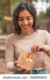 Vertical Portrait Of A Beautiful Young Indian Woman Eating French Fries