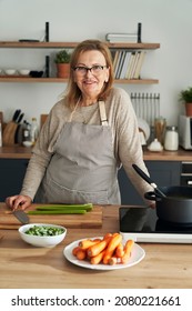 Vertical Portrait Of Caucasian Senior Woman Leaning In The Kitchen Island