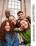 Vertical portrait of a group of friends having fun and smiling together. High school students looking at camera with happy expression. Young friendly real people staring front posing for a photo. High