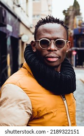 Vertical Portrait Of Happy Black African Ethnicity Man In Glasses And Black Scarf Outdoors, Looking At Camera.