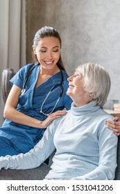 Vertical portrait of happy elderly woman with nurse at home