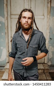 Vertical portrait of man with dreadlocks looking outside, studio shot.