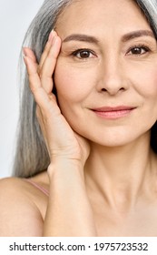 Vertical Portrait Of Middle Aged Asian Woman's Face With Perfect Skin. Older Mature Lady Touching Pampering Face With Hand. Advertising Of Cosmetology Salon Rejuvenating Spa Procedures Skincare.