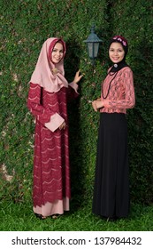Vertical portrait of muslim women in national clothing standing outside