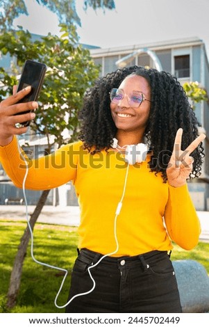 Vertical portrait smiling african american woman taking a self photo with a smartphone.