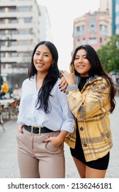 Vertical Portrait Of Two Hispanic Sisters Together In The Street. Friendship And Family.