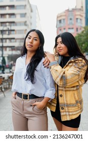 Vertical Portrait Of Two Hispanic Sisters Together In The Street. Friendship And Family.