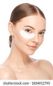 Vertical Portrait Of Young Beautiful Woman With Glowing Skin, Wearing One Eyepatch To Eliminate Puffiness, Isolated On White Background