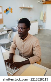 Vertical Portrait Of Young Black Software Developer Using Computer While Working In IT Office