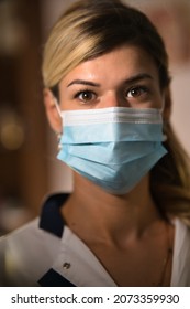 A Vertical Portrait Of A Young Nurse In A Mask Looking Straight Into The Camera