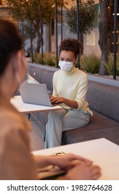 Vertical Portrait Of Young Woman Wearing Mask During Covid Safe Business Meeting In Cafe With Social Distancing