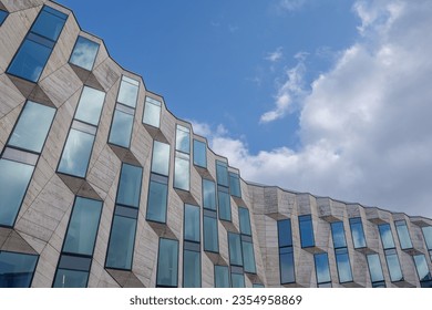 Vertical random pattern of rectangular glass windows and cream granite tile facade. 