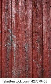 Vertical Red Barn Board Wall From Old Barn. Textured And Peeling Red Paint From Old Farm Building.