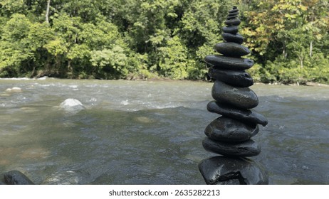 Vertical river stone stack in serene nature setting, reflecting inner peace, stability, and harmony—perfect visual for yoga, mindfulness, or eco retreat branding.