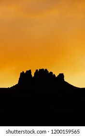 Vertical Rock Mesa Silhouette Under An Orange Sunset Sky In The Northern Arizona Desert