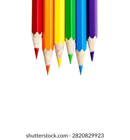 Vertical row of sharp rainbow colored pencils aligned on white background