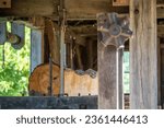 Vertical saw and cut log with wood grain tree rings and tree bark in open air colonial American sawmill in Pennsylvania, historic early American industry