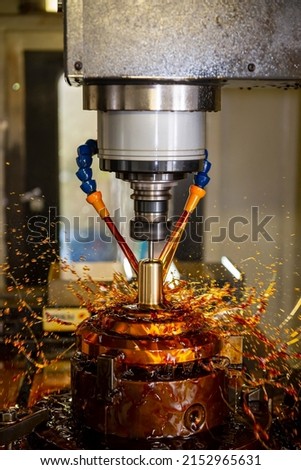 The vertical scene CNC milling machine cutting the shell mold parts with oil coolant method. The mold and die manufacturing process by CNC machining center with oil coolant method.