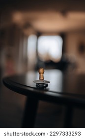A vertical selective focus shot of a bronze baby pacifier on a table