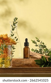 Vertical setup featuring brown dropper bottle, glass cup with marigold flowers, and wooden props. Surrounded by eucalyptus and green herbs. Bright yellow backdrop and natural shadows.