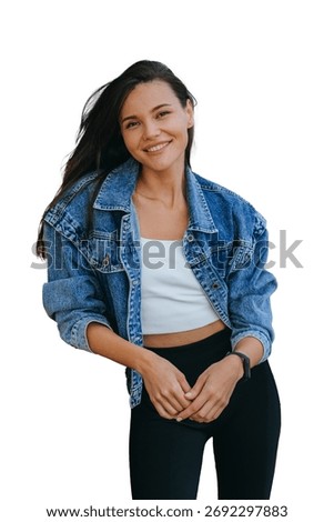 Vertical shoot of cheerful multiethnic model on  transparent background dressed in jeans jacket and black leggings looks at camera broad smiles. Cheerful Asian girl waits for boyfriend outside.  