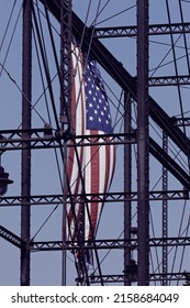 A Vertical Shot Of American Flag On Iron Girder 