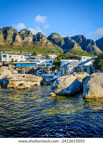 Vertical shot of Bakoven, Camps Bay beach, seaside houses and the Twelve Apostles mountain in the background, Cape Town, South Africa