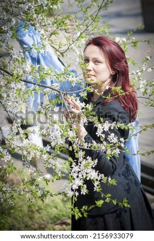 A vertical shot of a beautiful red headed Caucasian woman surrounded by small flowers