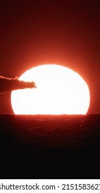 A Vertical Shot Of A Beautiful Sunset Over The Water With A Single Cloud In The Shot, Over A Red Background