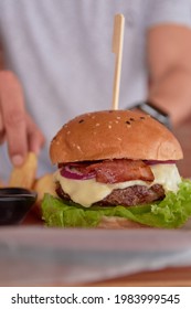 A Vertical Shot Of Big Juicy Burger With Bacon And Melted Pepper Jack Cheese