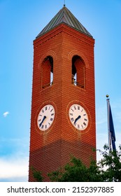 A Vertical Shot Of A Brick Clock Tower Against The Blue Sky