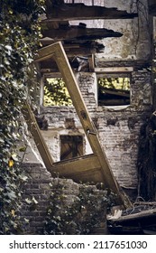 A Vertical Shot Of A Broken Door Frame And House Ruins 