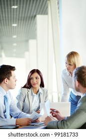 Vertical Shot Of Business People Gathered For A Meeting