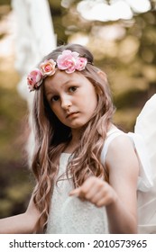 A Vertical Shot Of A Caucasian Blonde Girl With A Flower Hairband Under Sunlight