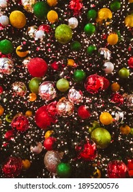 A Vertical Shot Of A Chrismtas Tree With Multicolored Balls And Lights