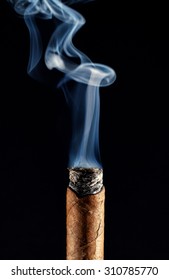 Vertical Shot With Cigar Smoke Rising From The Burning Toback