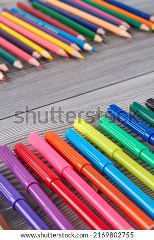 Vertical shot close up colorful felt-tip pens. Grey wooden desk.