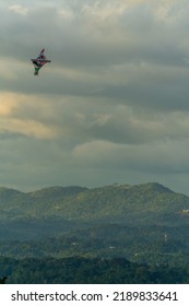 A Vertical Shot Of A Colorful Kite Flying Over Mountains In Cloudy Weather