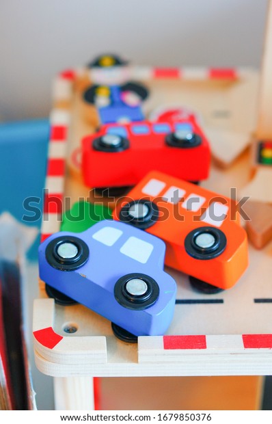 A vertical shot of colorful wooden car toys on a\
wooden surface